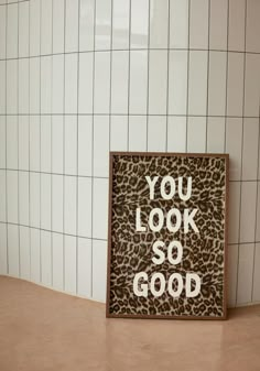 a sign that says you look so good on the floor in front of a tiled wall