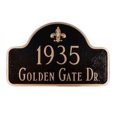 a black and gold plaque with a fleur de lis design on it that reads, 1933 golden gate dr