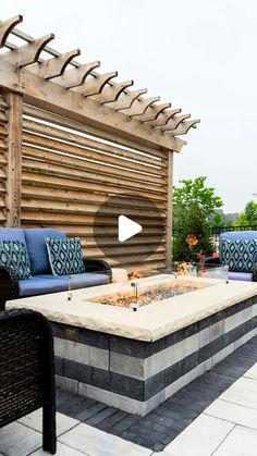 a fire pit sitting on top of a patio next to a wooden pergoline