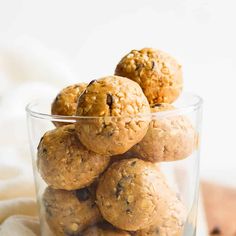 a glass bowl filled with oatmeal energy bites on top of a wooden table