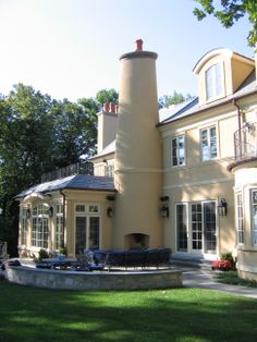 a large house with a tall chimney in the middle of it's back yard