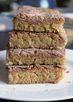 three pieces of cake sitting on top of a white plate with powdered sugar over them