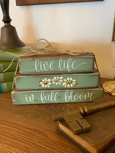 three books are stacked on top of each other with the words live life in all bloom painted on them