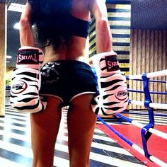 a woman wearing zebra print boxing gloves in a room with black and white striped flooring