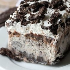 a close up of a piece of cake on a plate with oreo cookies and cream