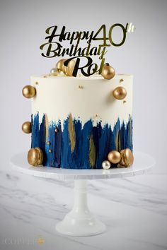 a birthday cake decorated with gold and blue icing