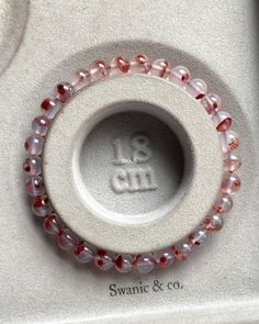 a close up of a ring made out of beads on a white surface with the words swanic & co in it