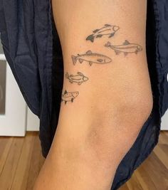 a person with a tattoo on their leg that has fish drawn on it and arrows pointing in different directions