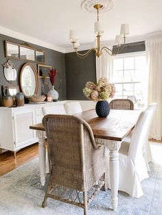 a dining room table with white chairs and a blue rug on the floor in front of it