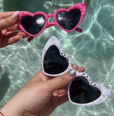 two pairs of sunglasses with the word paris written on them, in front of a swimming pool