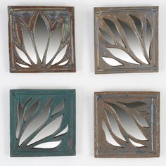 four decorative mirrors mounted to the side of a wall