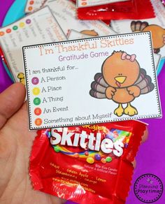 a hand holding a candy bar with the label for skittles