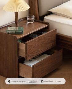 a wooden night stand with two drawers and a lamp on the nightstand next to it