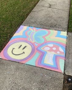 a sidewalk with a painted smiley face on it and grass in the backgroud