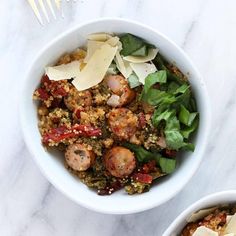 two white bowls filled with food on top of a table next to a fork and knife