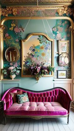 a pink couch sitting in front of a mirror on top of a wooden floor next to a wall