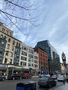 cars are driving down the street in front of tall buildings