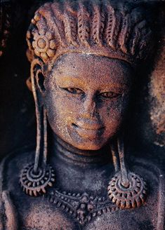 a close up of a statue of a person wearing ear rings and headdress