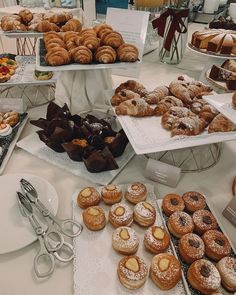 a table topped with lots of different types of donuts and pastries on trays