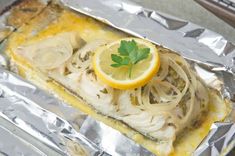 an image of fish with lemon and parsley on it's side in foil