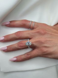 a woman's hand with two rings on her finger and one ring in the other