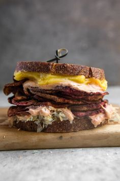 a sandwich with meat and cheese on a cutting board