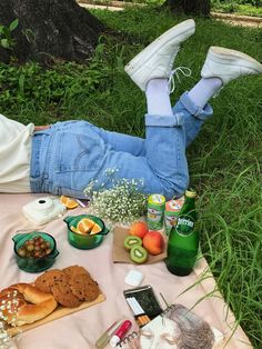 a person laying on the ground with food and drinks