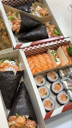 three boxes filled with different types of sushi