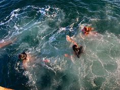 several people swimming in the ocean with their backs turned