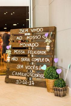 a wooden sign sitting on top of a counter next to a potted plant in front of a door