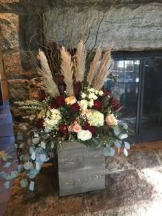 a vase filled with flowers sitting on top of a stone fireplace place next to a brick wall