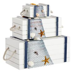 three white boxes are stacked on top of each other with starfish and seashells