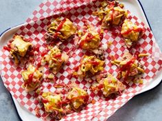 some food is laying on a red and white checkered plate