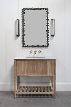 a bathroom vanity with a mirror above it and two lights on the wall next to it