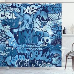 a bathroom with blue and white graffiti on the shower curtain next to a bath tub