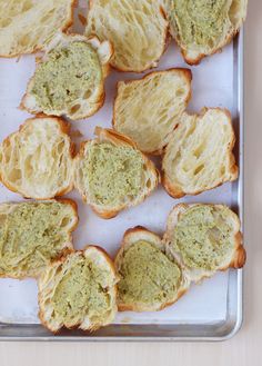 several pieces of bread with pesto spread on them