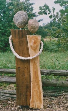 two rocks sitting on top of a piece of wood