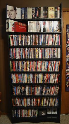 a book shelf filled with lots of books next to a wall mounted television set and remote control