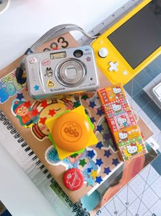 a digital camera sitting on top of a table next to other toys and paper crafts