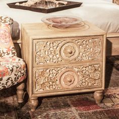 a bedroom with a bed, two chairs and a tray on the end table in front of it