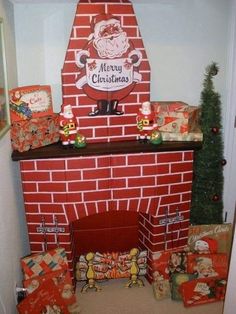 a christmas fireplace with presents around it and santa clause on the top shelf, surrounded by gifts