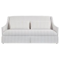 a white and blue striped couch with two pillows on top of the armrests