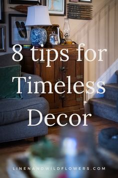 a living room filled with furniture and pictures on the wall next to a stair case