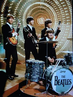 the beatles on stage with their instruments