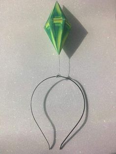 a green kite is being flown on the ground with string attached to it's tail