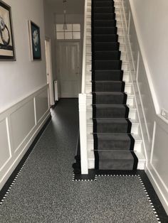 a black and white carpeted staircase leading up to the first floor in a house