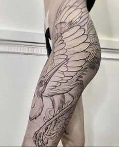 a woman's leg with a bird tattoo on it and an eagle in the background