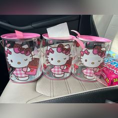 hello kitty cups are sitting on the back seat of a car, with pink bows