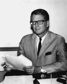 a man sitting at a desk with papers in his hands