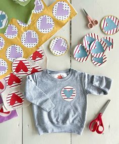 the baby sweaters and scissors are laid out on the table